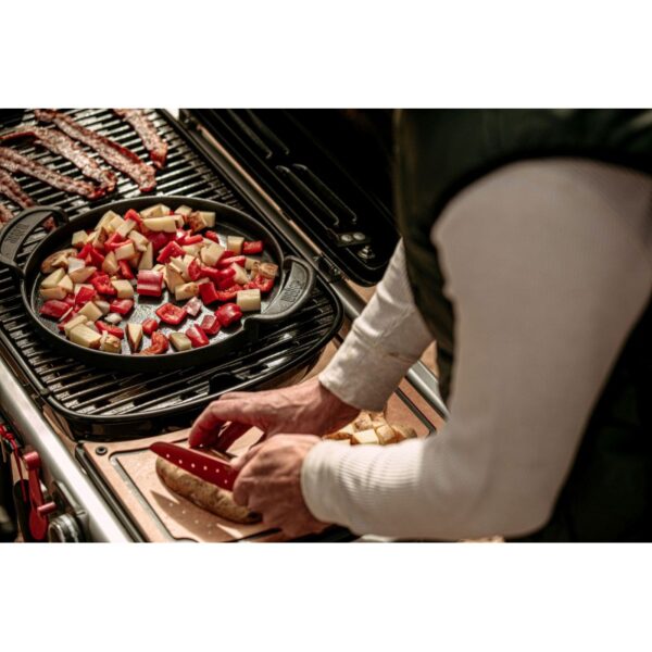 Persona cocinando verduras en parrilla al aire libre.