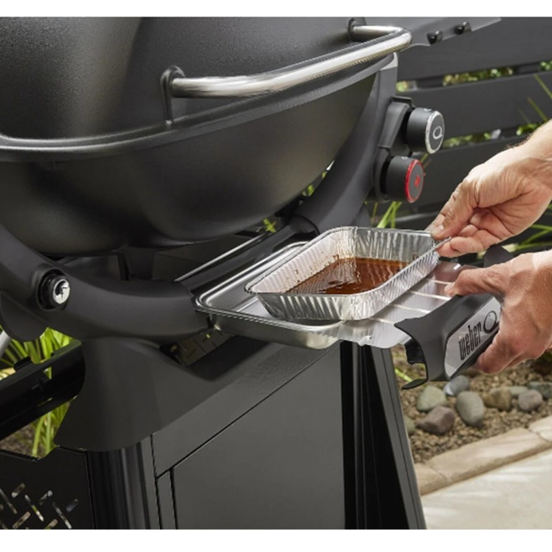 Bandeja de aluminio con salsa en barbacoa Weber.