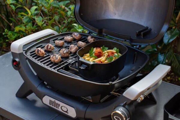 Parrilla con salchichas y pasta al aire libre