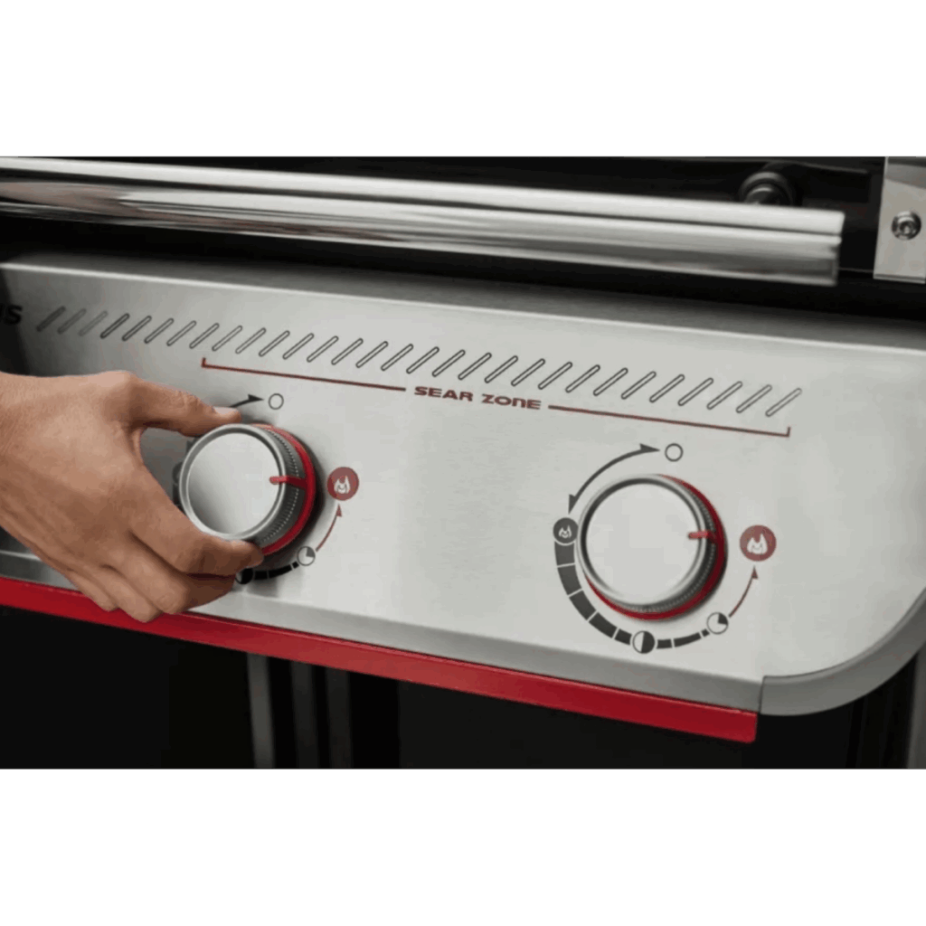 Mano ajustando mando de parrilla a gas moderna.