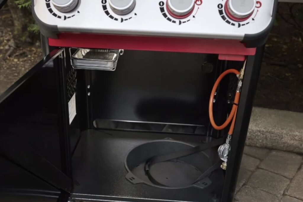 Interior de barbacoa con reguladores de gas visibles.