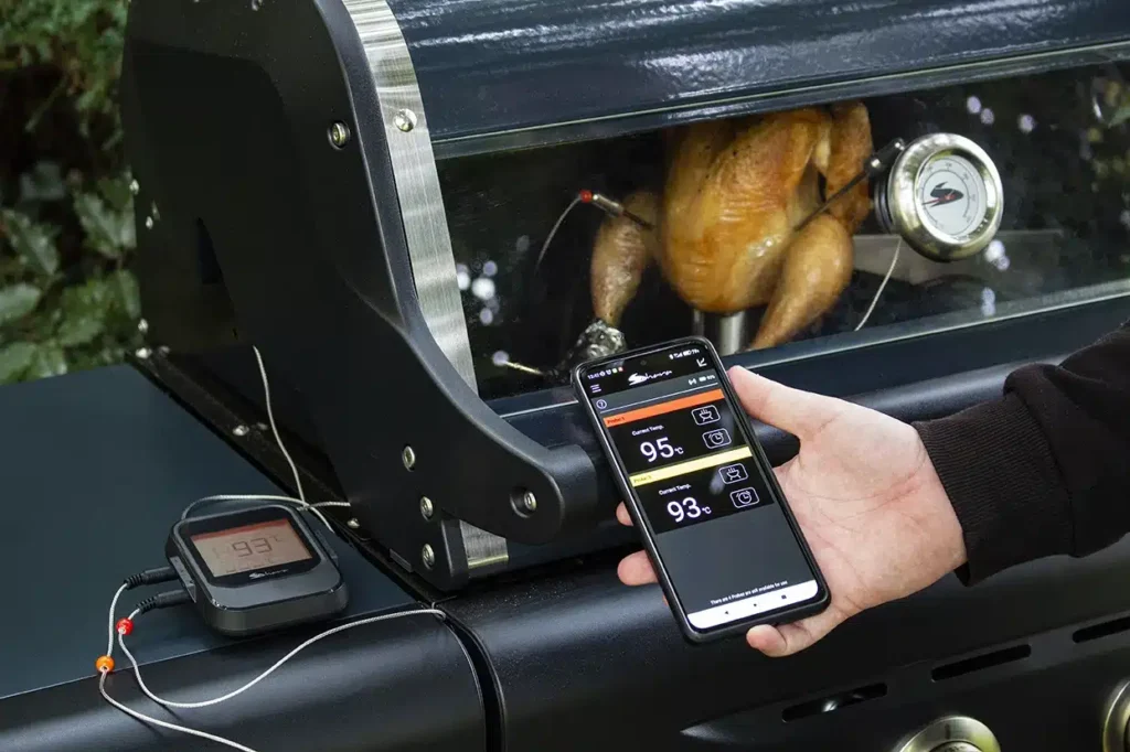 Monitoreo asado de pollo con app en móvil.
