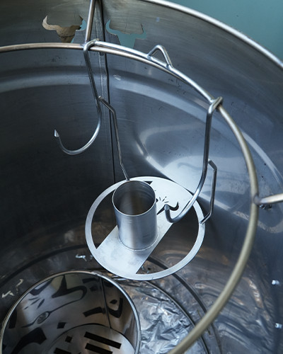 Interior de tambor metálico industrial con ganchos