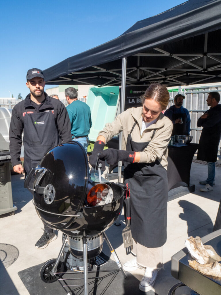 Personas cocinando en una barbacoa al aire libre