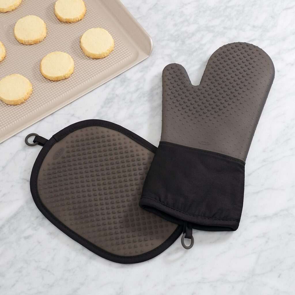 Guantes de cocina y bandeja con galletas.