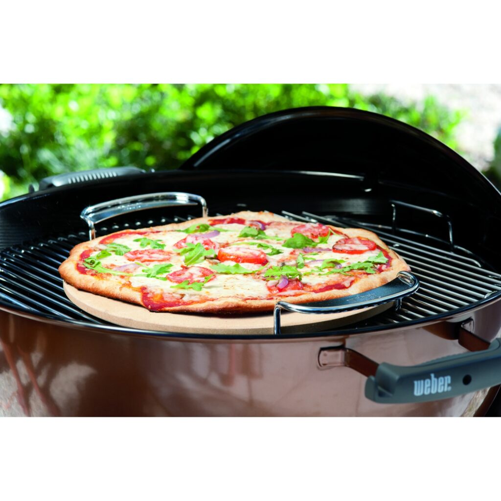 Pizza cocinándose en una barbacoa Weber.