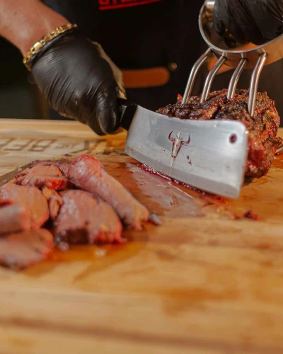Corte de carne asada en tabla de madera.